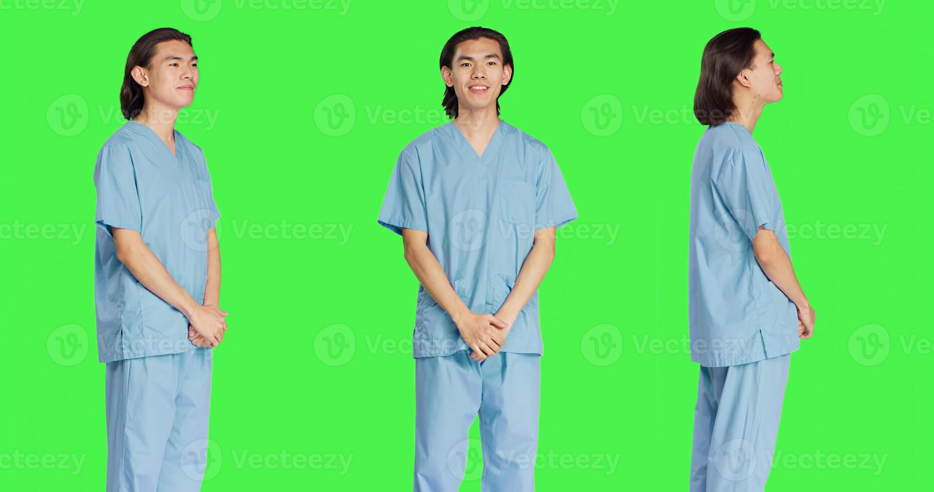 Asian male nurse posing in studio with confidence, wearing hospital uniform and standing with arms crossed against greenscreen. Young medical assistant healthcare specialist with skill. photo