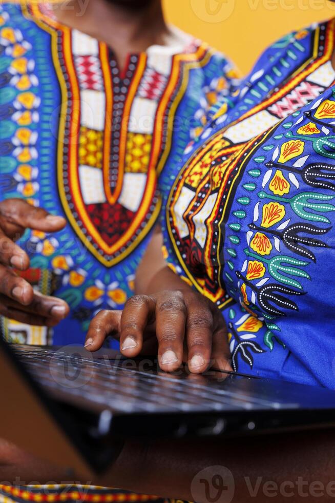 Black man and woman using laptop and scrolling internet page with touchpad closeup. African american couple holding fingers on portable computer close view while typing message photo