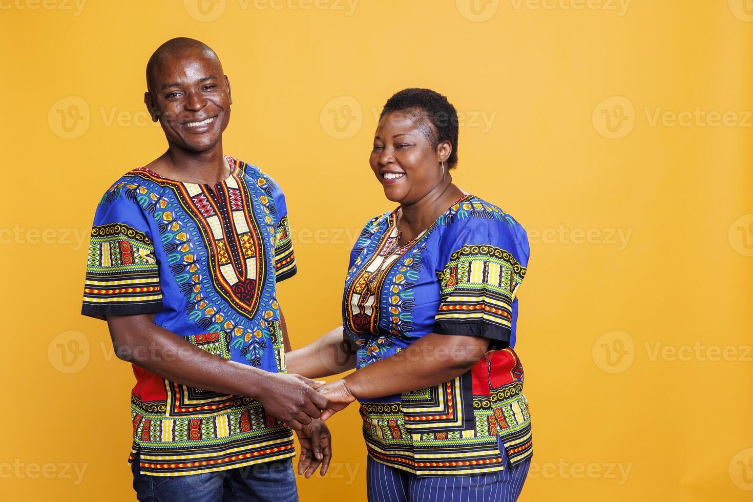 Smiling happy mid adult couple holding hands and posing together for family portrait. Man and woman spouse with cheerful expression showing affection and looking at camera photo