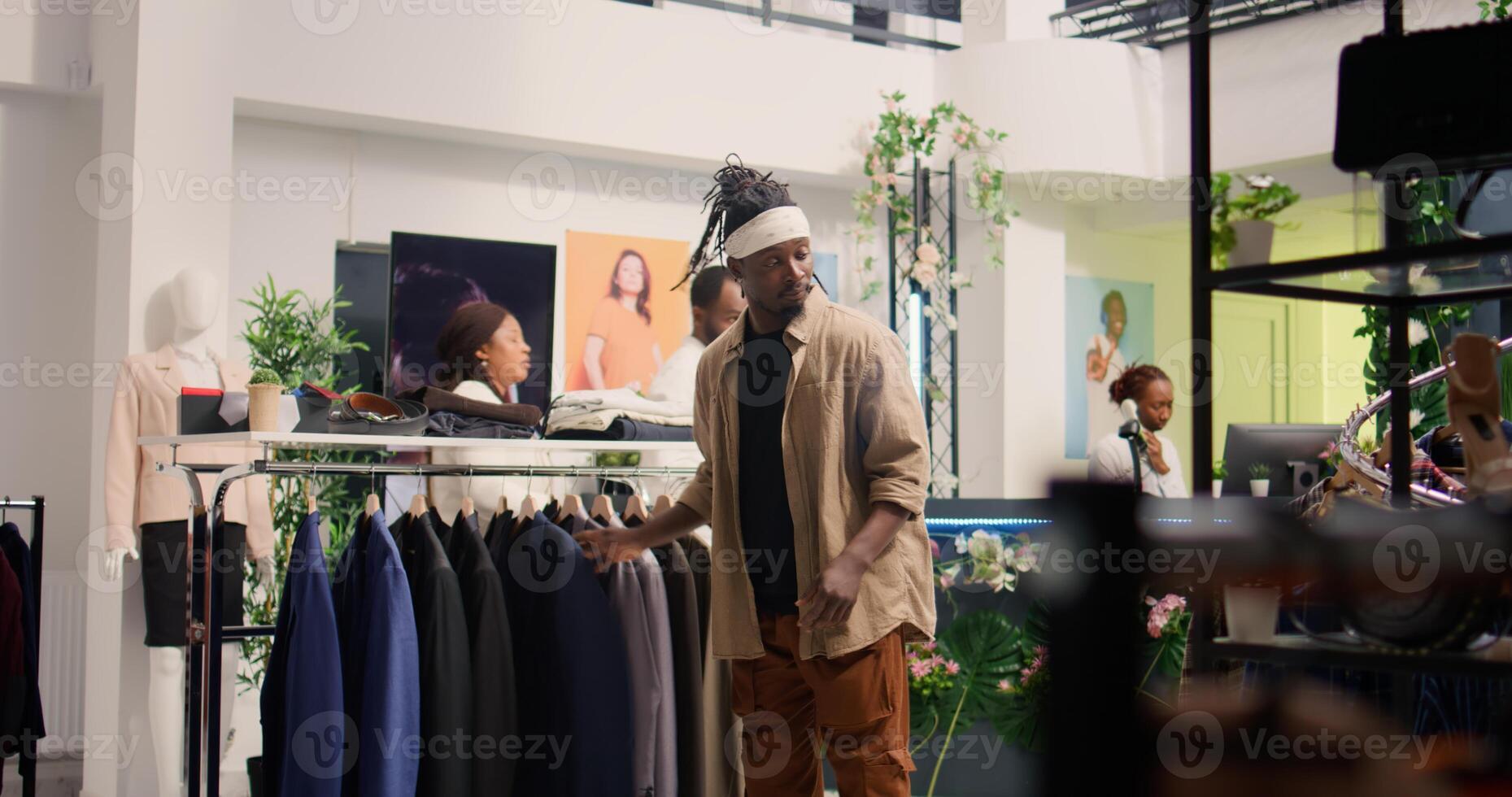 Customer arriving in clothing store during promotional season, looking to buy cheap garments to fill his wardrobe. Man taking advantage of sales in fashion boutique, looking at elegant blazers photo