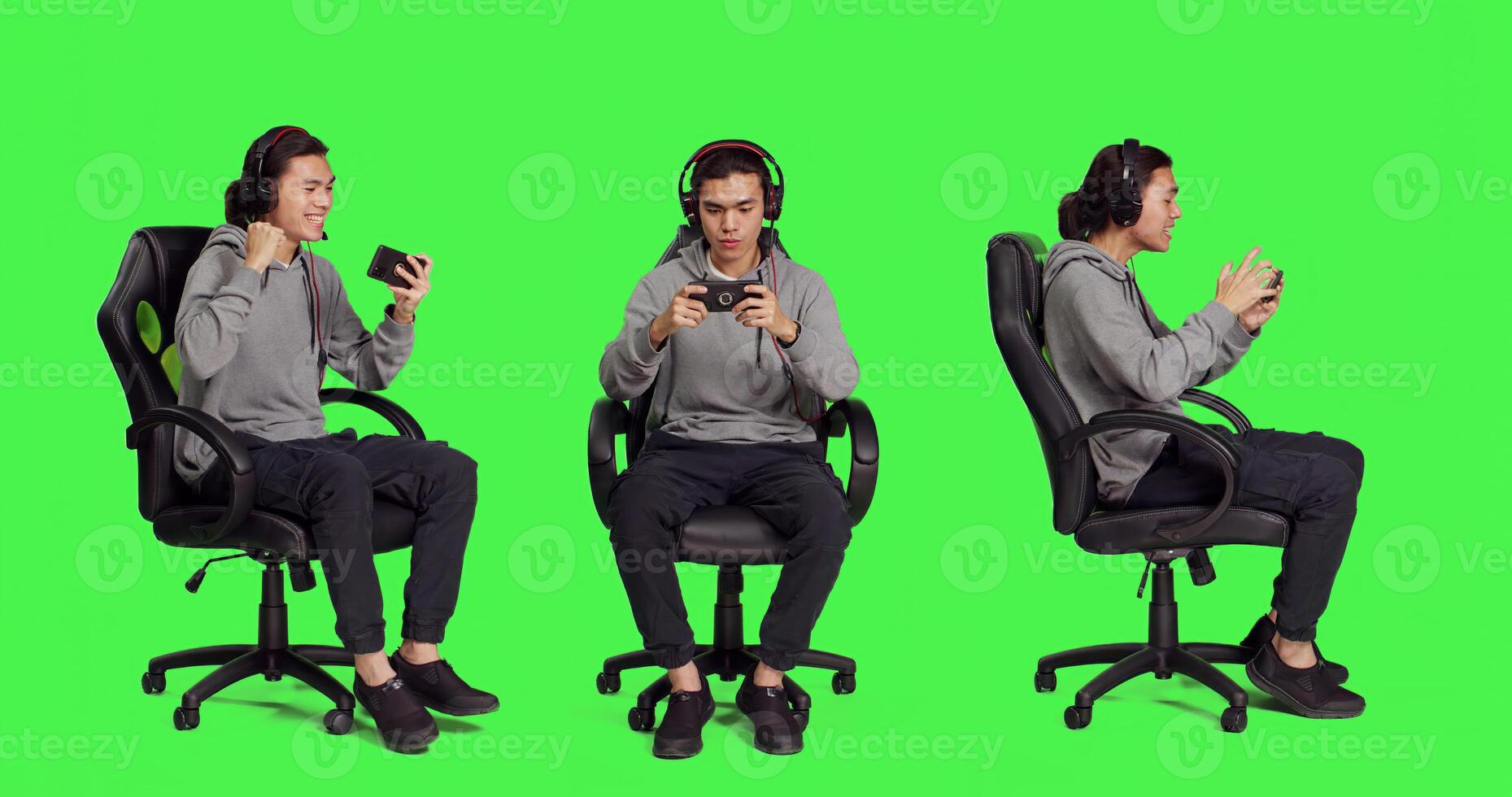 Asian guy sitting in chair over greenscreen, performing games on mobile device. Young man utilizing phone to engage in smartphone games, web roleplaying contest with players. photo