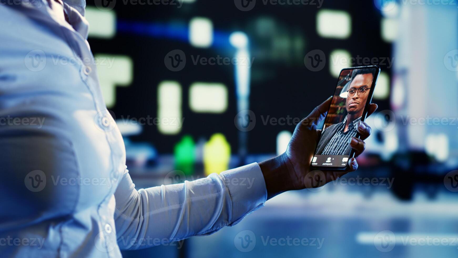 Close up shot of african american woman talking with husband in online videocall while wandering around dimly illuminated empty city streets at night, needing company to feel safe photo