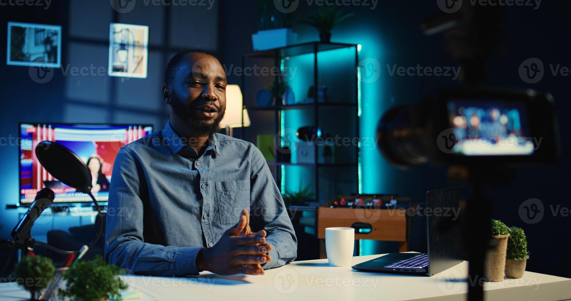 Smiling influencer in cozy home using professional camera to film live broadcast for online streaming platforms. Internet star hosts q a session with audience members using recording equipment photo