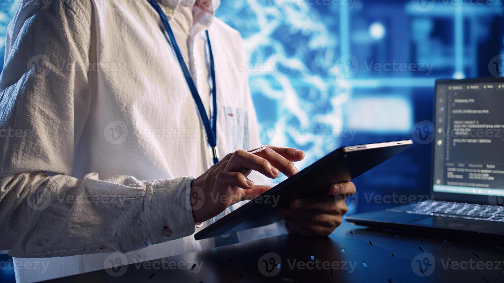 Computer scientist in data center, solving tasks on tablet while running programming scripts on laptop terminal. Certified engineer manipulating lines of code for AI applications development photo