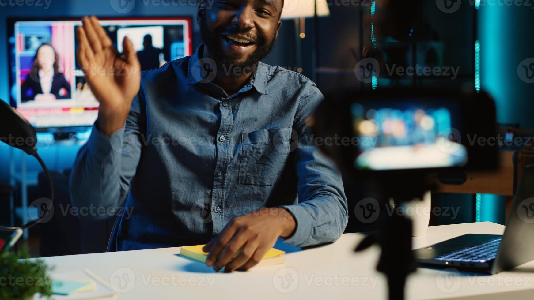 African american content creator films review of book, presenting synopsis to audience and giving feedback. Internet star sponsored by publisher to show new novel release to subscribers photo