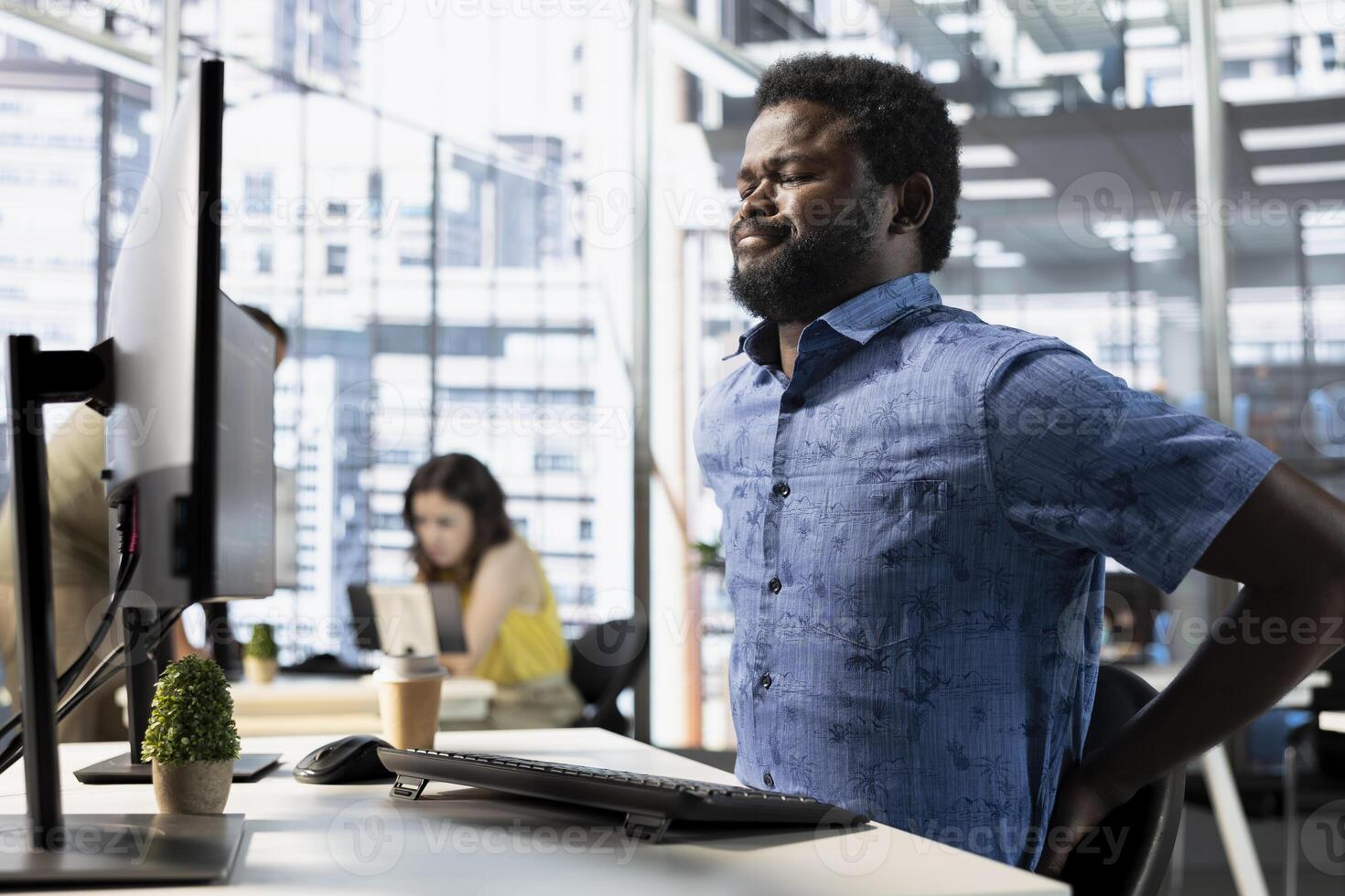 Worker suffering backache from incorrect posture, working with machine learning tech advancing AI. Tired IT expert feeling muscle strain, stretching, transforming data into predictive models photo