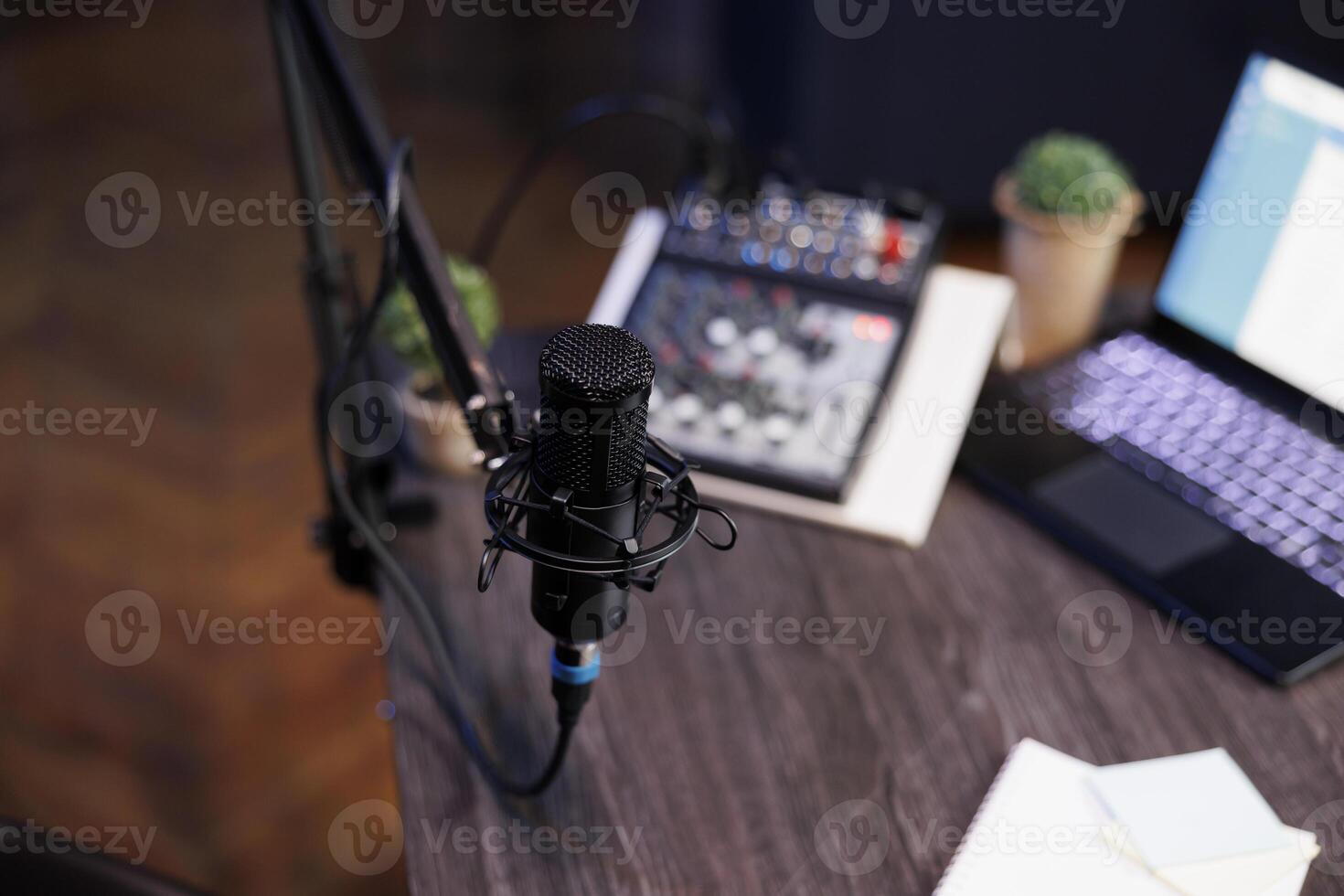Home recording setup for a radio show or podcast, featuring a microphone, laptop, and sound equipment. Top view of desk containing professional mic and sound mixer, ideal for home studio. photo