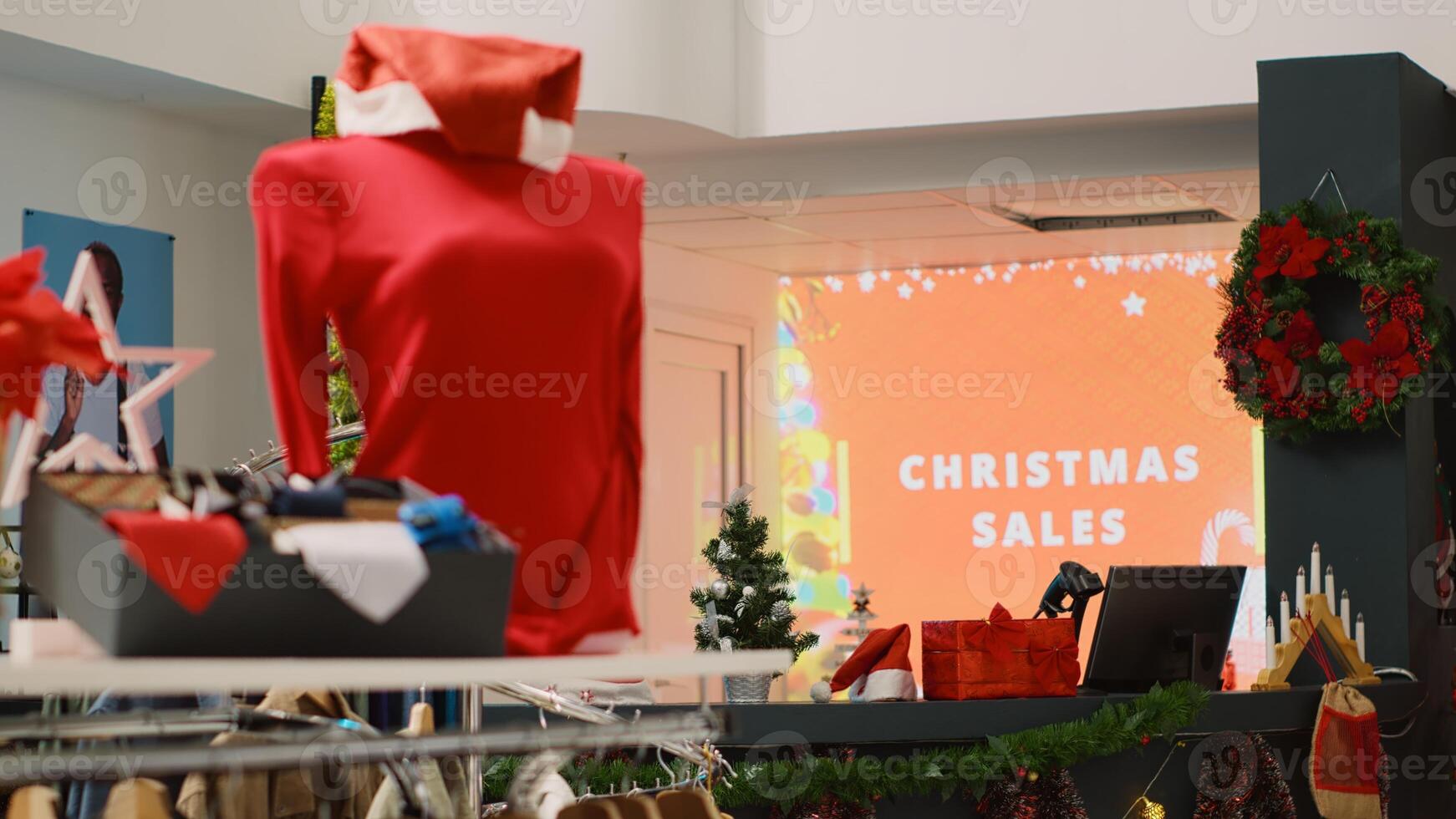 Led display advertisement in xmas decorated clothing store announcing Christmas sales. Promotional animated billboard inviting customers looking for bargains in festive adorn shop photo
