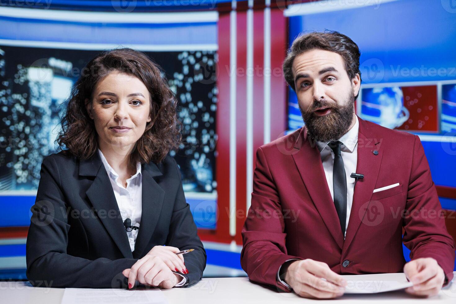 Team of presenters giving news updates reporting latest information and global events in newsroom. Two journalists working on television content, discussing international topics. photo
