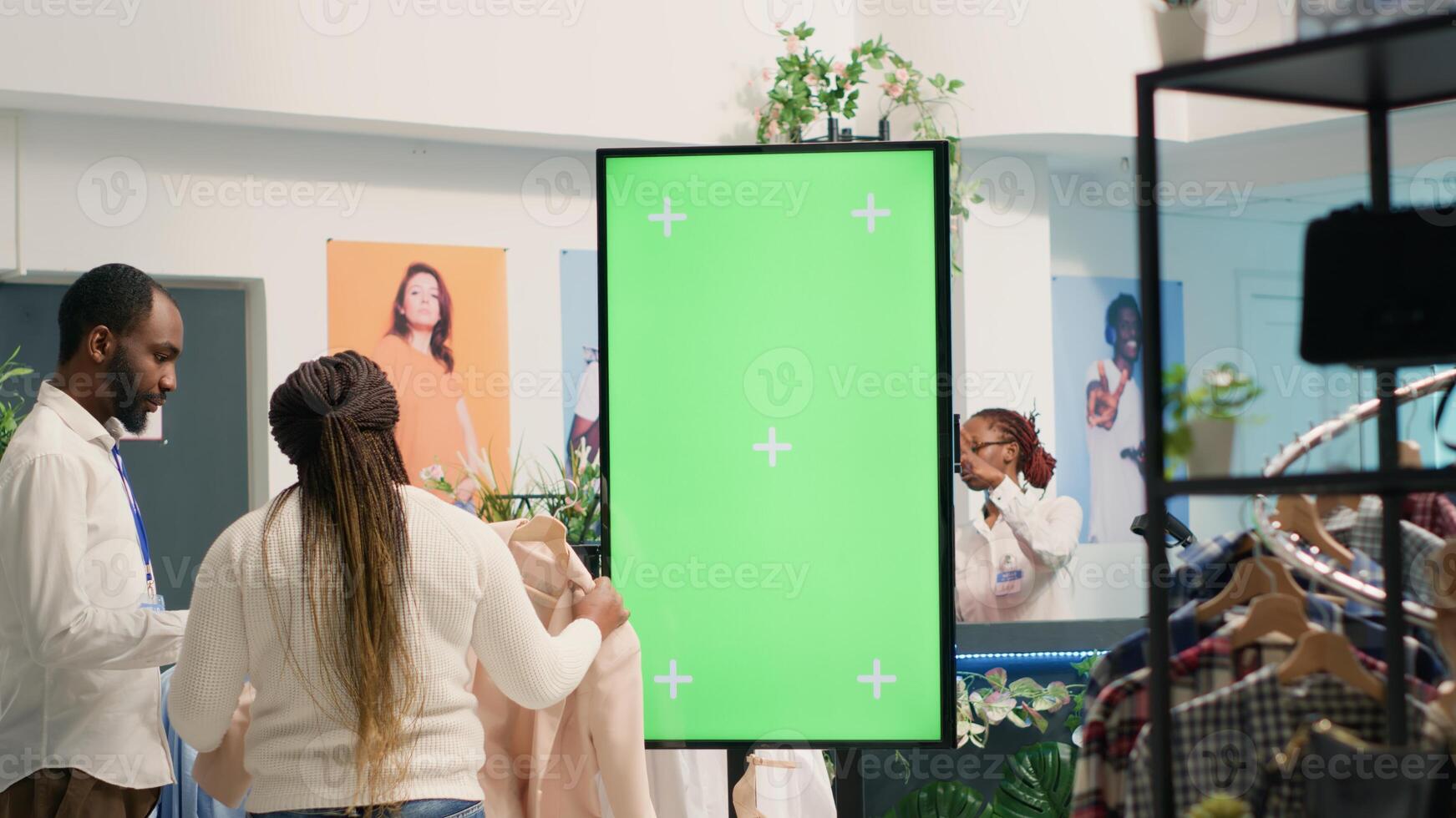 Green screen kiosk in luxury clothing shop advertising new collection of elegant formalwear clothes. Chroma key mockup digital display in fashion boutique used to promote store garments photo