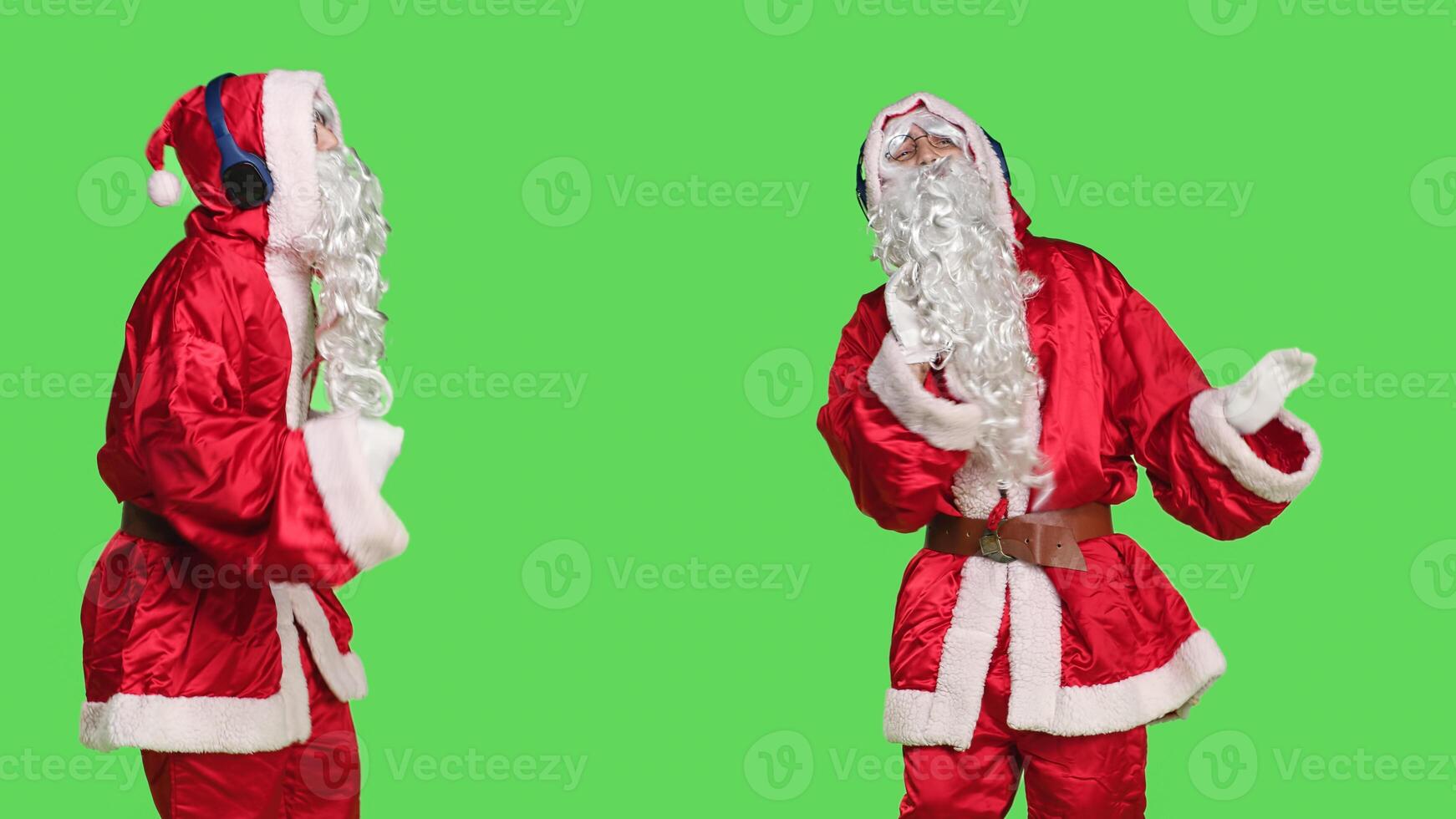 Positive seasonal character having fun on camera, dancing around greenscreen backdrop with headphones. Santa claus happy person enjoying modern songs in studio, christmas holiday. photo