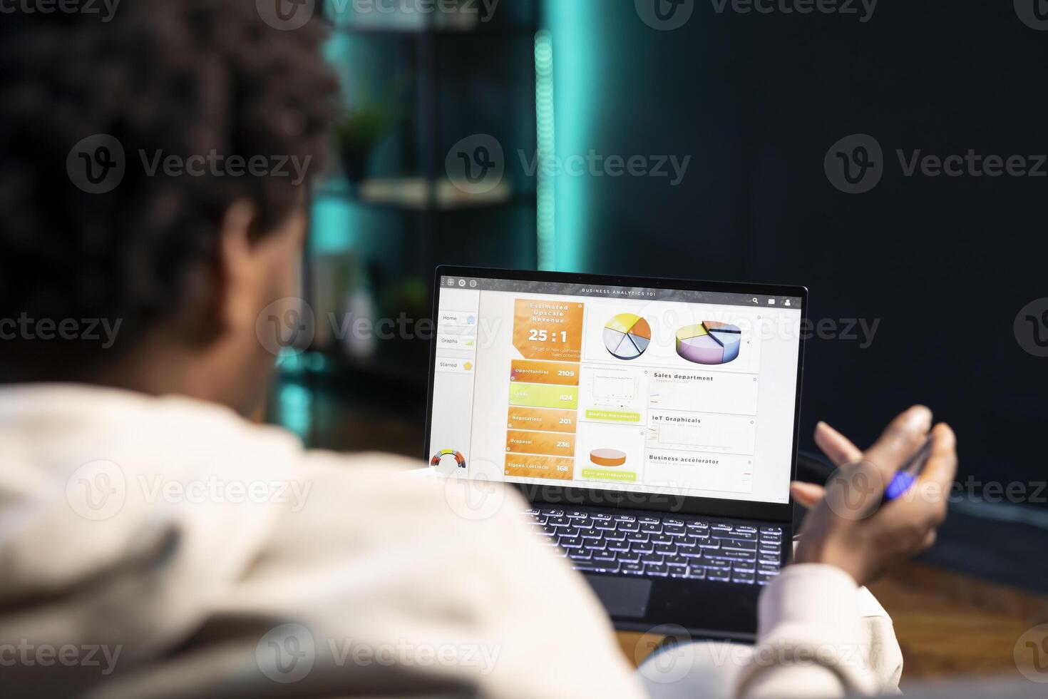 Remotely working accountant at home doing math calculations using financial graphs on laptop. Self employed man in apartment comparing business charts economic figures on notebook screen photo