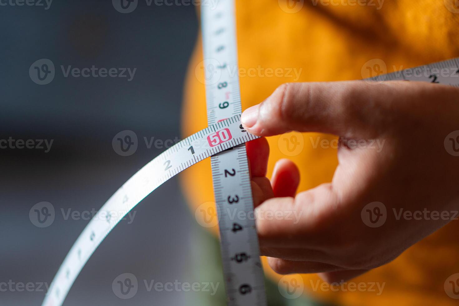 Close-Up of Hand Holding Measuring Tape photo
