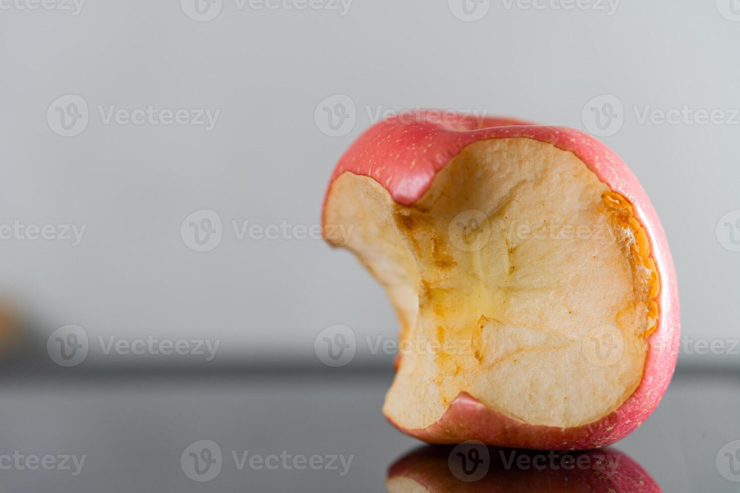 Bitten Red Apple on Reflective Surface photo