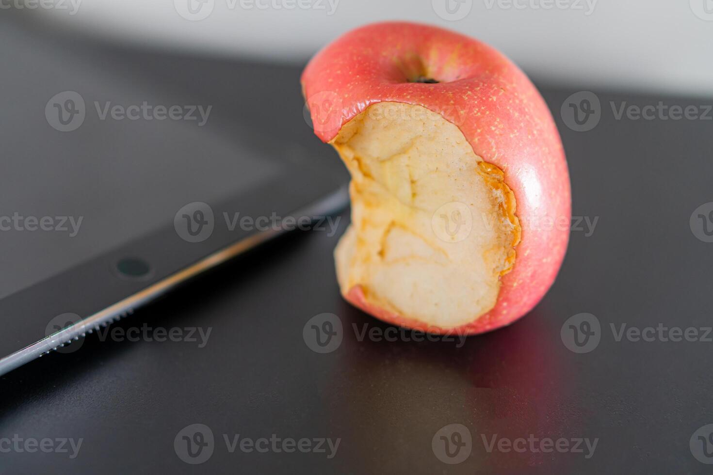 Partially Eaten Apple Next to Tablet photo