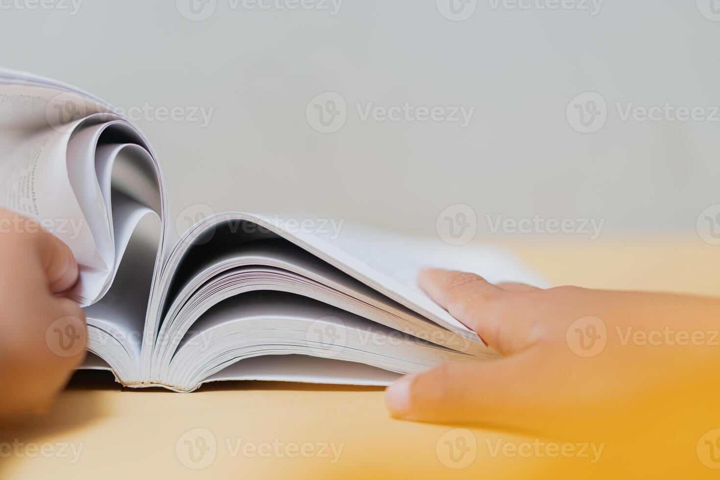 Close-Up of Hands Flipping Pages of an Open Book photo