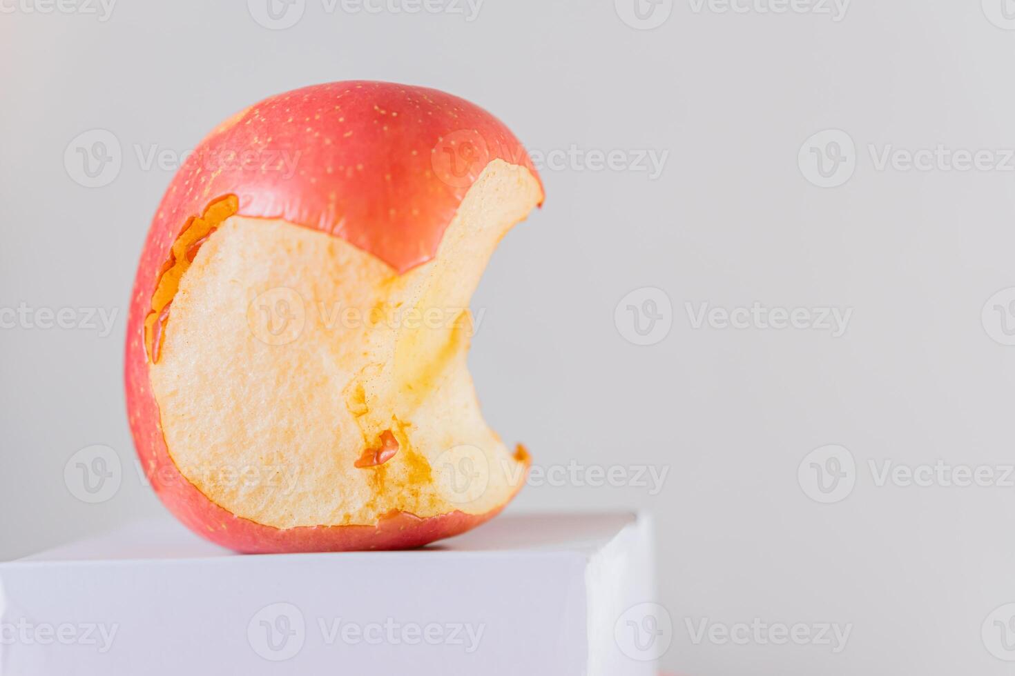 Partially Eaten Red Apple on White Surface photo