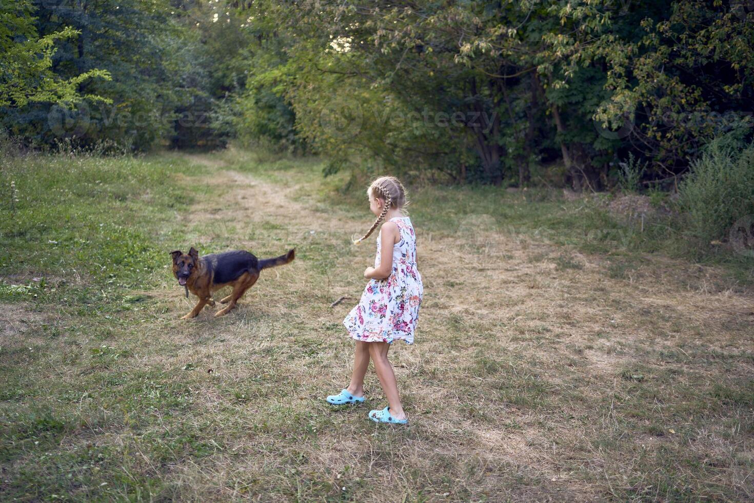 little girls sisters play with german shepherd dog during easter picnic in the garden photo
