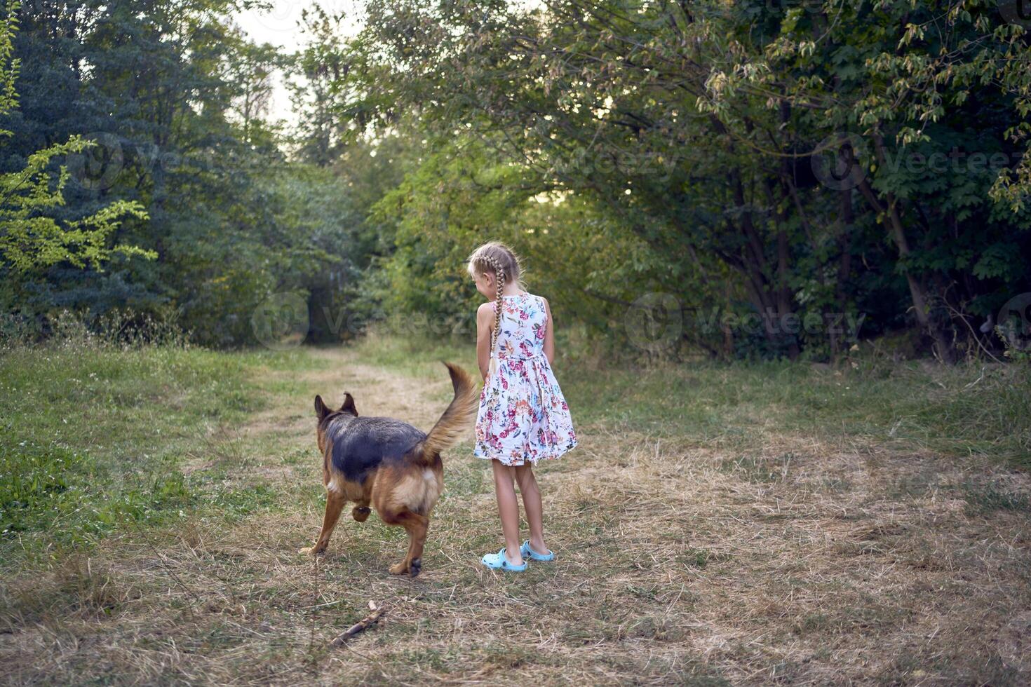 little girls sisters play with german shepherd dog during easter picnic in the garden photo