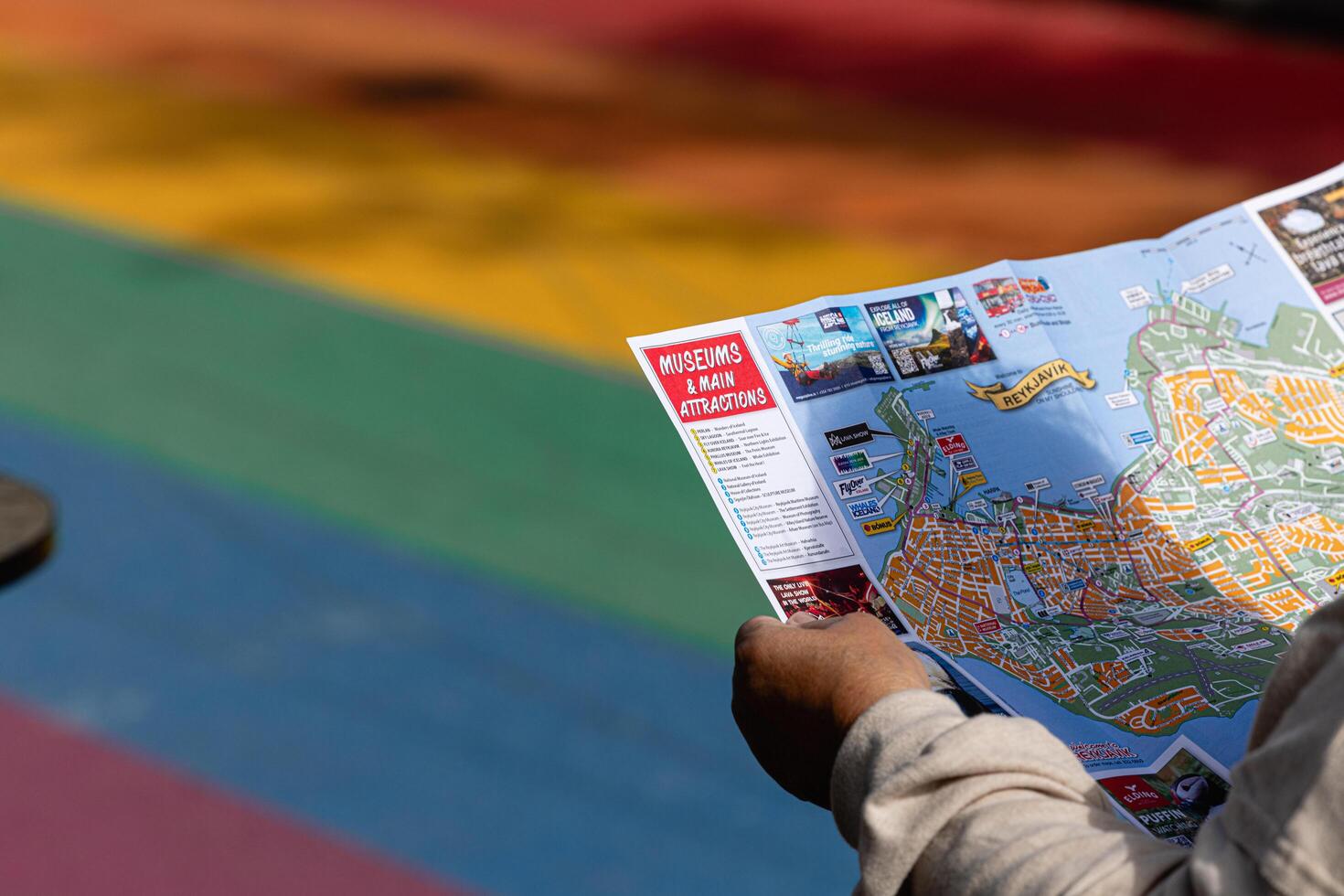 July 9 2024 Reykjavik Iceland. A tourist looks at a map of Iceland on the famous Rainbow Street, a well known attraction in Reykjavik, during the most popular month for tourism, July. photo