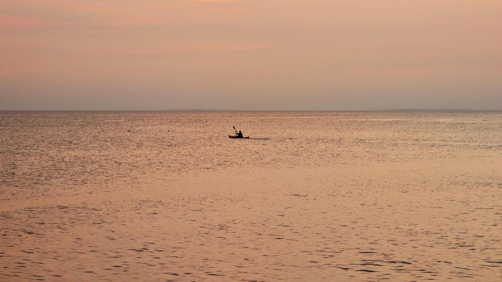 person kayaking at sunset in ocean at wild Atlantic way, sport and recreation, activity, seascape and nature background photo