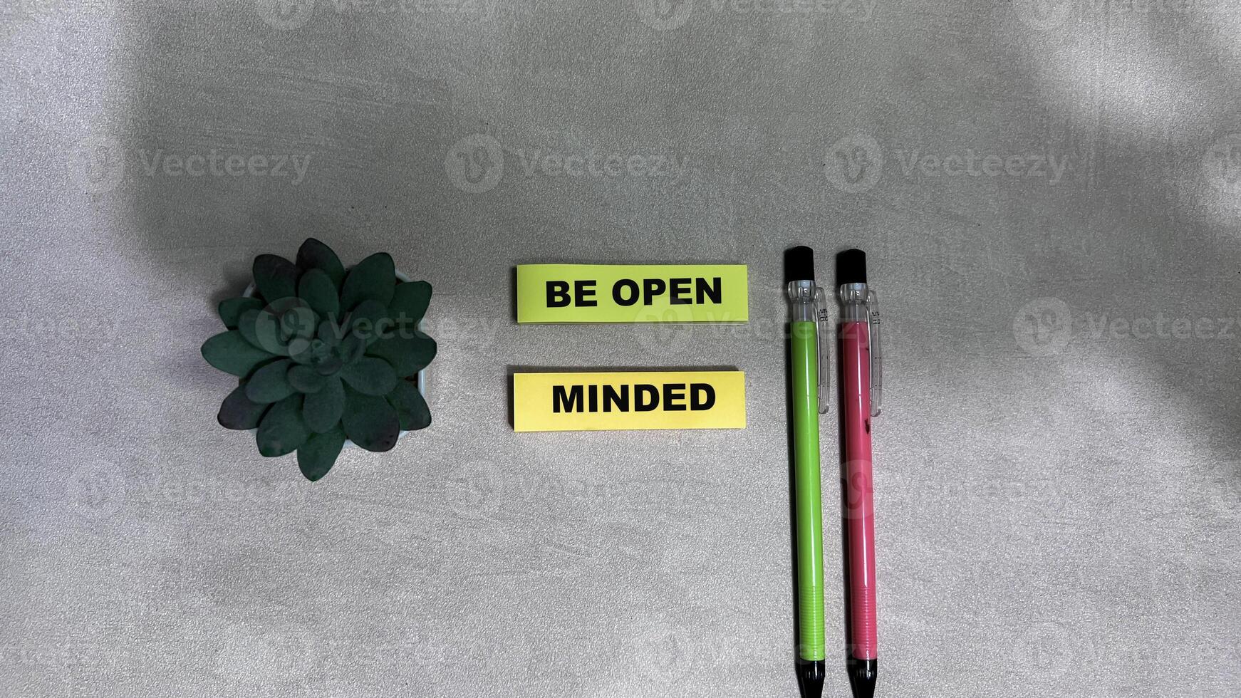 Concept of Be Open Minded write on sticky notes isolated on Wooden Table. photo