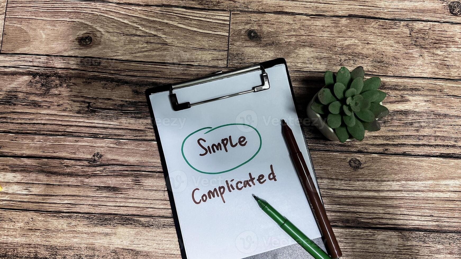 Concept of Simple or Complicated write on paperwork isolated on wooden background. photo