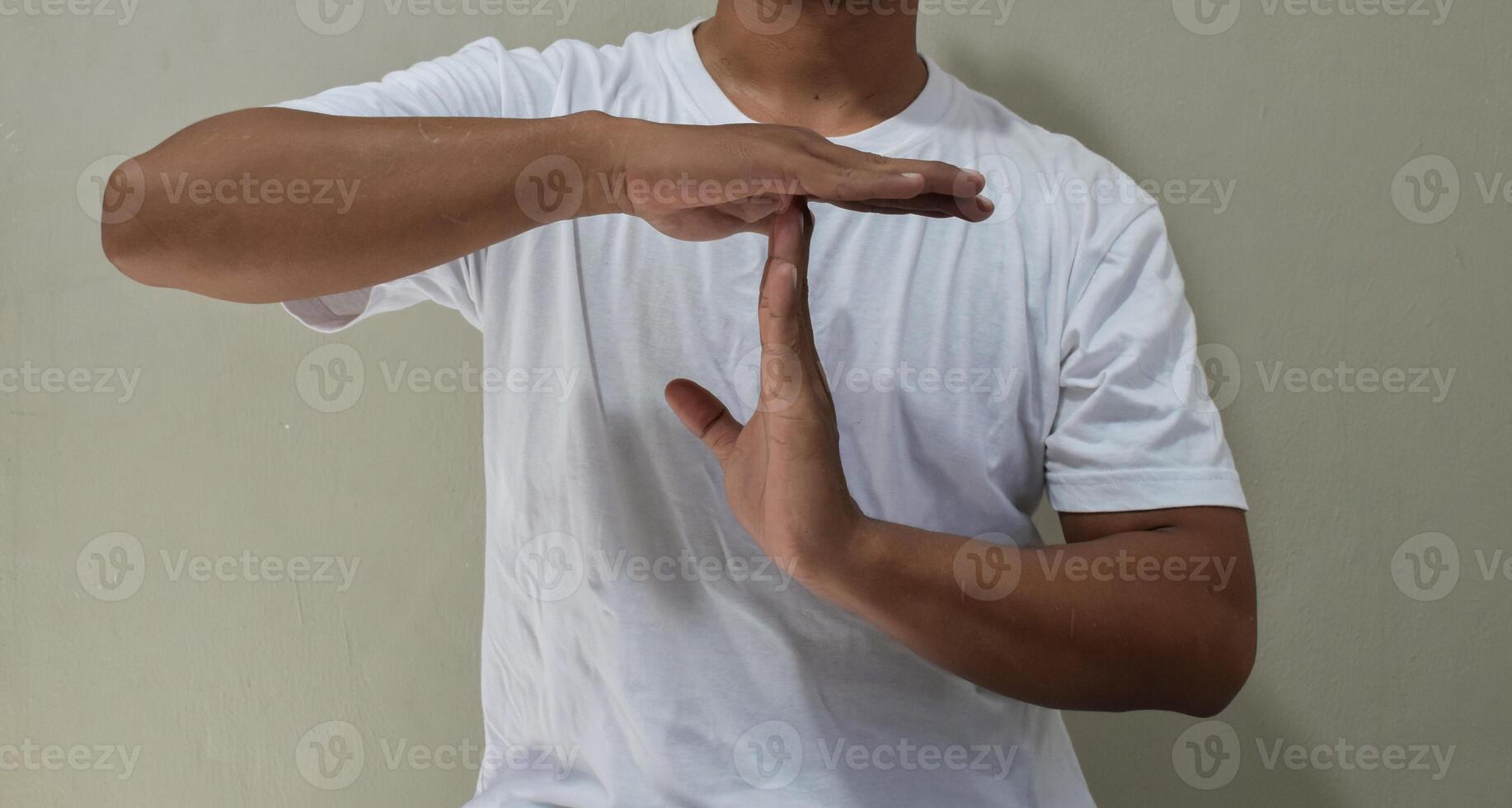 Young man showing a pause time out gesture with hands photo