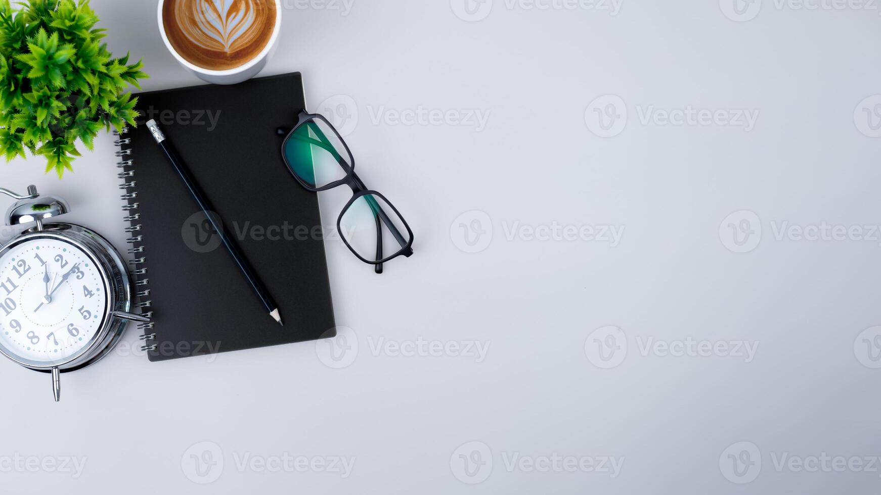 Top view white workspace office desk with office supplies. Flat lay work table with black notebook, Green leaf and coffee cup, Copy space for your advertising content. photo