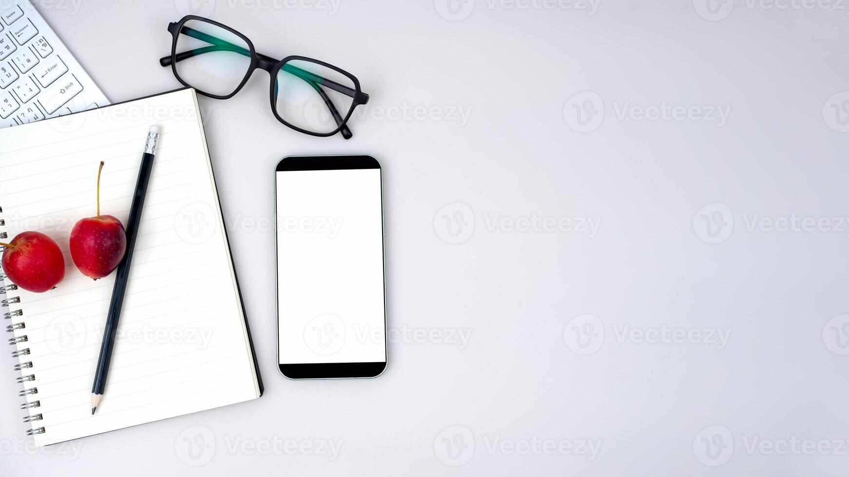 Top view of mock up modern workspace with blank screen smartphone, keyboard. Office situation with keyboard and accessories isolated on white. Copy space, Flat lay. photo