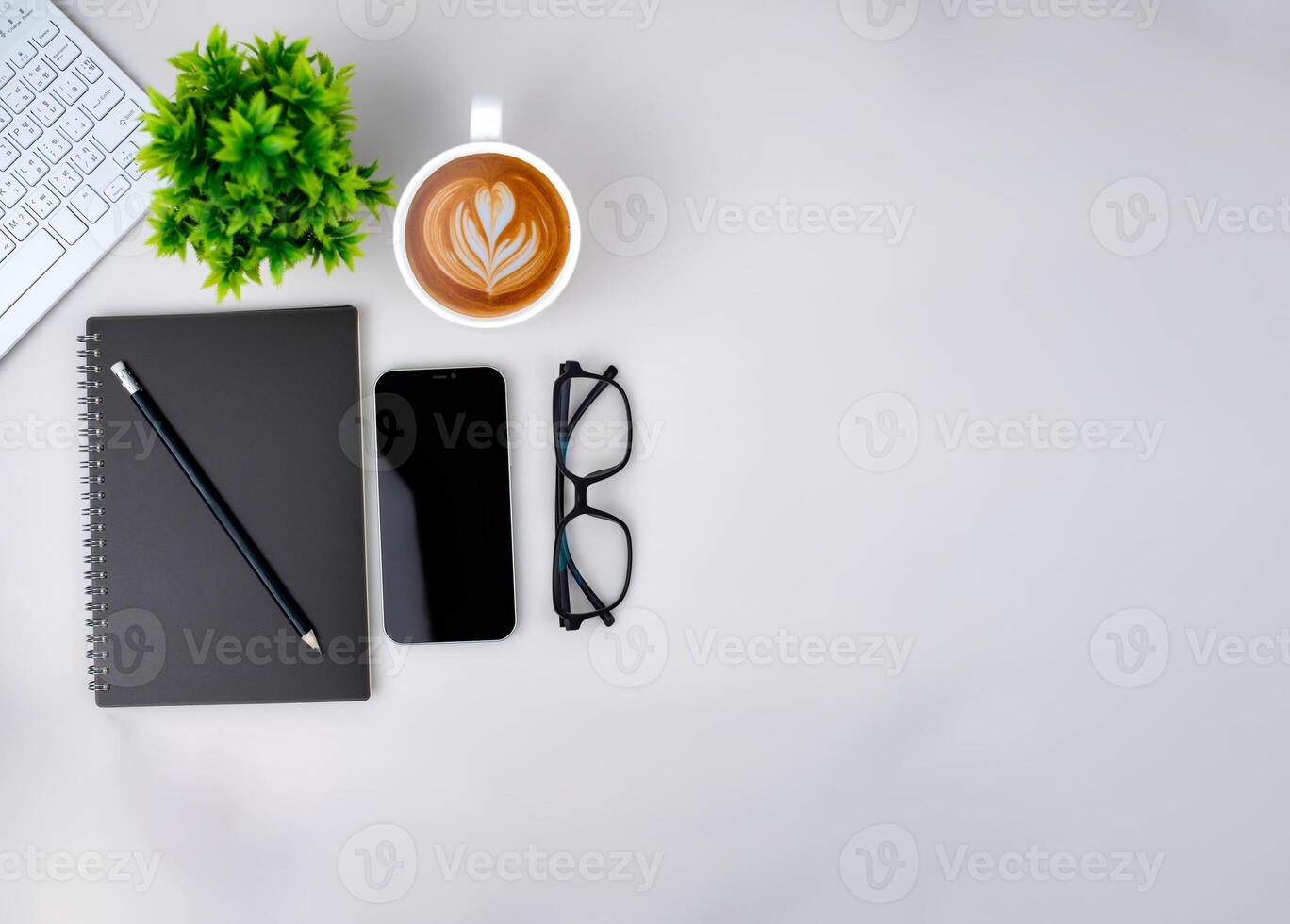 Top view of mock up modern workspace with blank screen smartphone, Keyboard, Coffee cup, Notebook, Glasses. Office situation with keyboard and accessories isolated on white. Copy space, Flat lay. photo