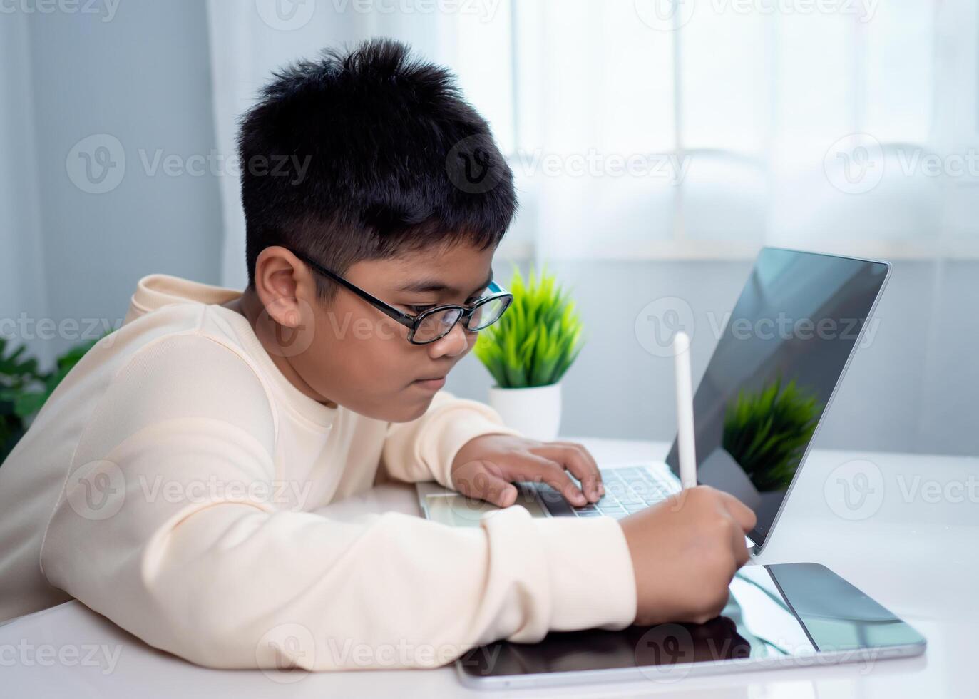 Asian student boy using computer and tablet learning. Educational of tech concept, Staying at home, Presenting a modern educational way of life. Virtual internet online class from school teacher. photo