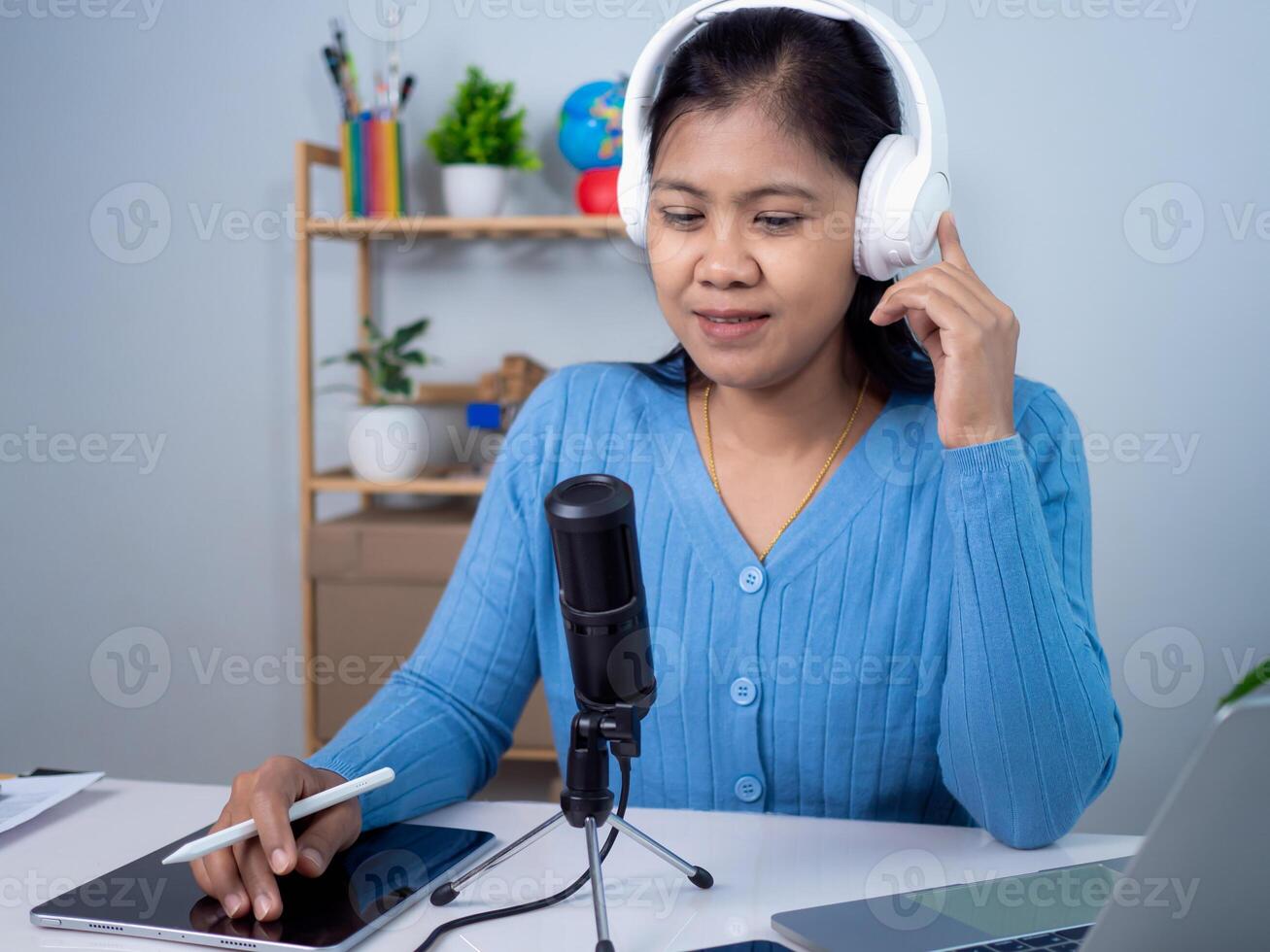 Woman talking into microphone on stand, Content creator concept, Lead on-line communication, Discuss topic, looks at notebook screen, Engaged in streaming, Virtual meeting event, Podcast, Webinar. photo