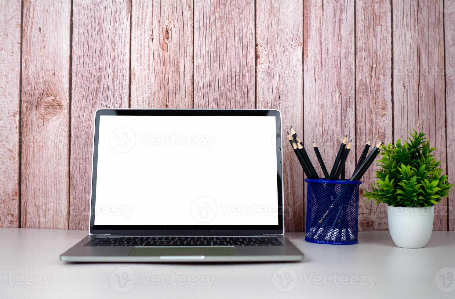 Laptop with blank screen on white table and office supplies on wooden background. Space for copying your text. Workspace and copy space. Desk with office supplies. photo