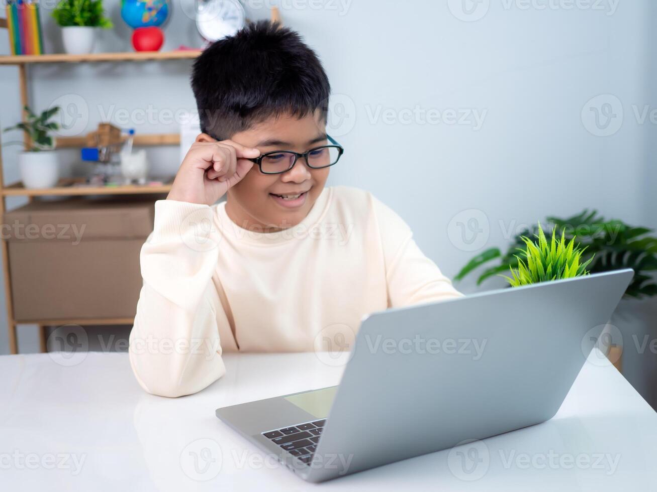 Asian boy student using computer laptop learning. Educational of tech concept, Staying at home, Presenting a modern educational way of life. Virtual internet online class from school teacher. photo