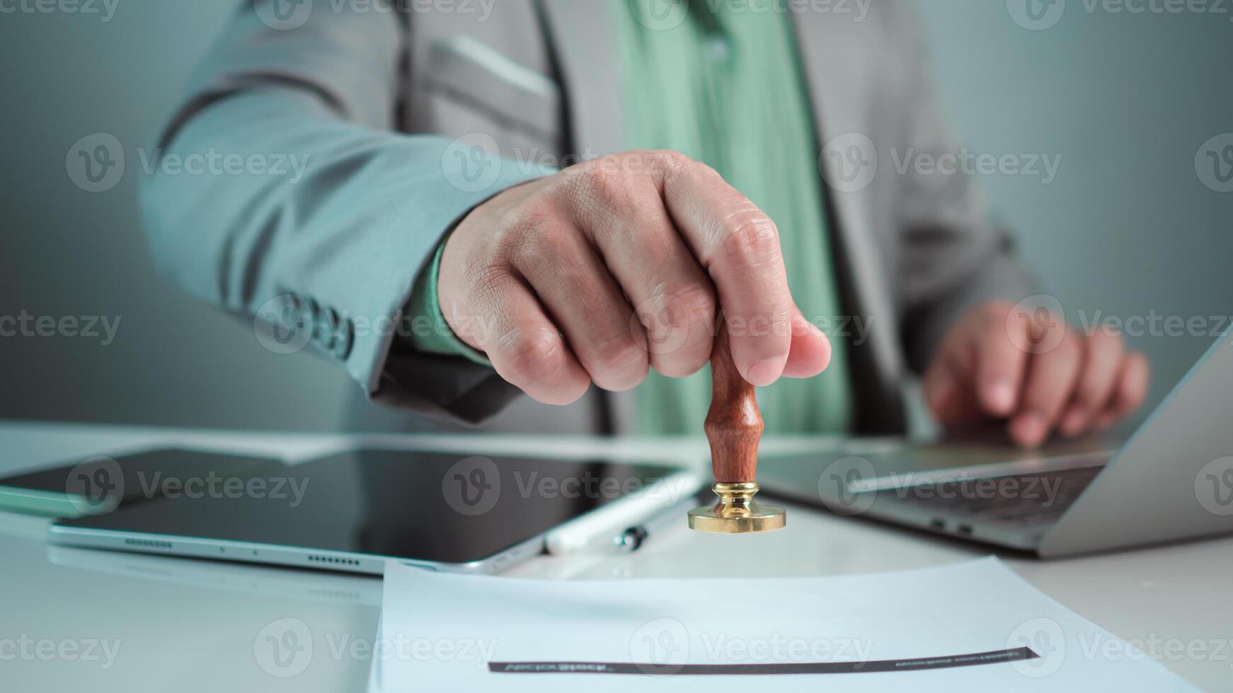 Businessman hand stamping with approved stamp on text approved document at desk, Validates and manages business documents and agreements, Approval stamp, Signing on business partner paper to success. photo
