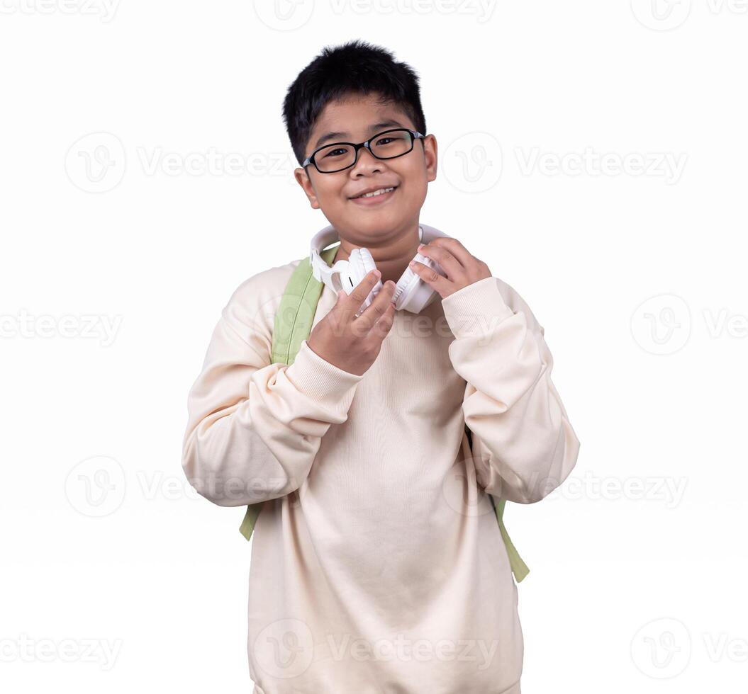 Portrait of school boy in casual clothes carrying a green bag and white headphones isolated on a white background, The concept of education and way of life, Cute boy posing in casual clothes. photo