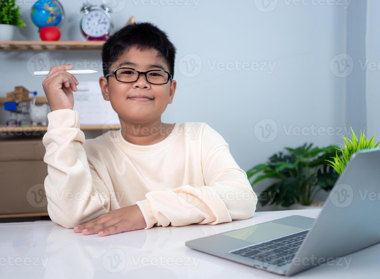 Little Asian boy student using computer laptop learning. Educational of tech concept, Staying at home, Presenting a modern educational way of life. Virtual internet online class from school teacher. photo