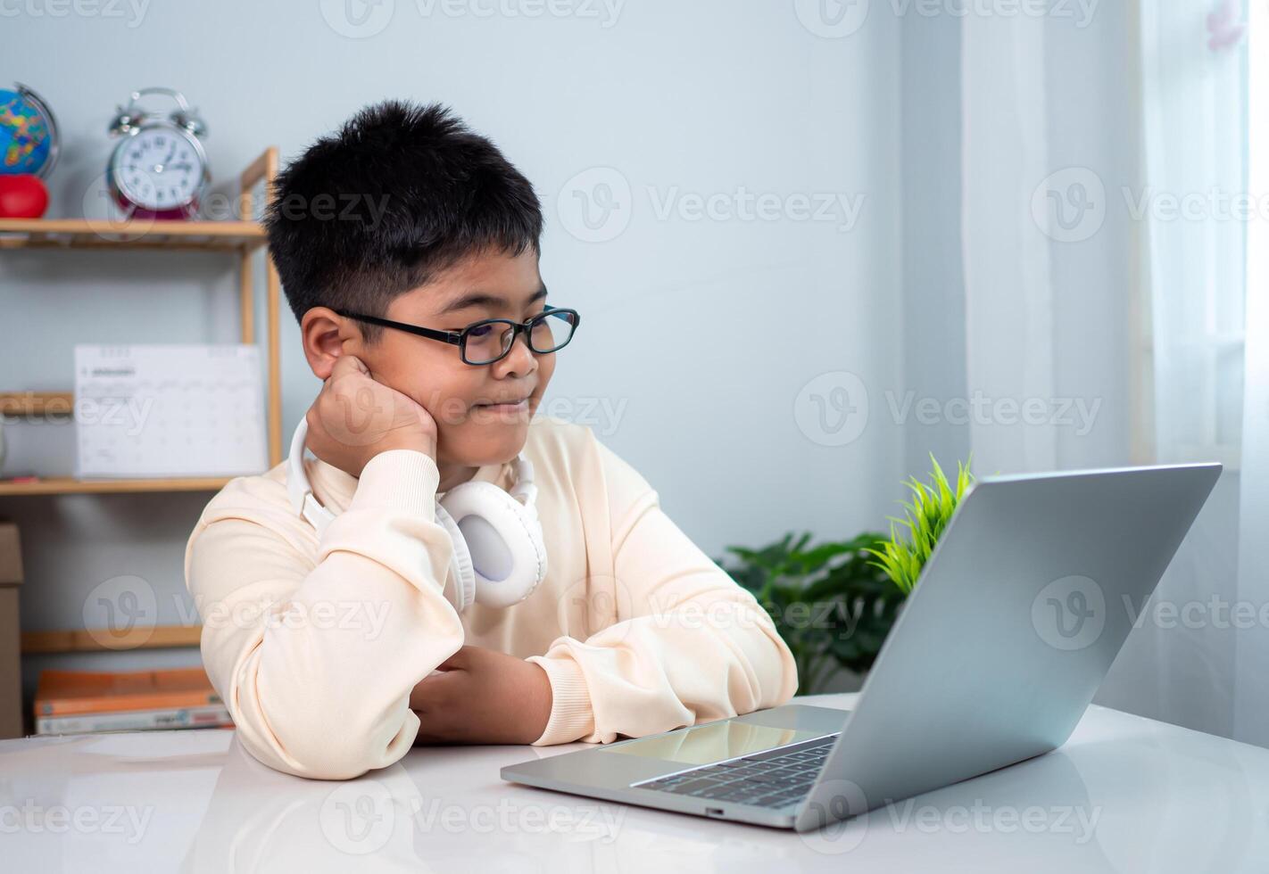 Little Asian boy student using computer laptop learning. Educational of tech concept, Staying at home, Presenting a modern educational way of life. Virtual internet online class from school teacher. photo