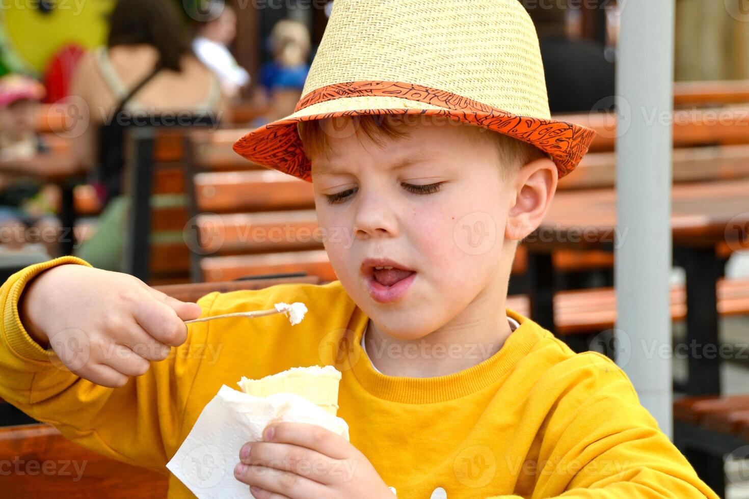 Happy child, boy eating ice cream on the beach, enjoying summer, playing. Halkidiki, Greece photo