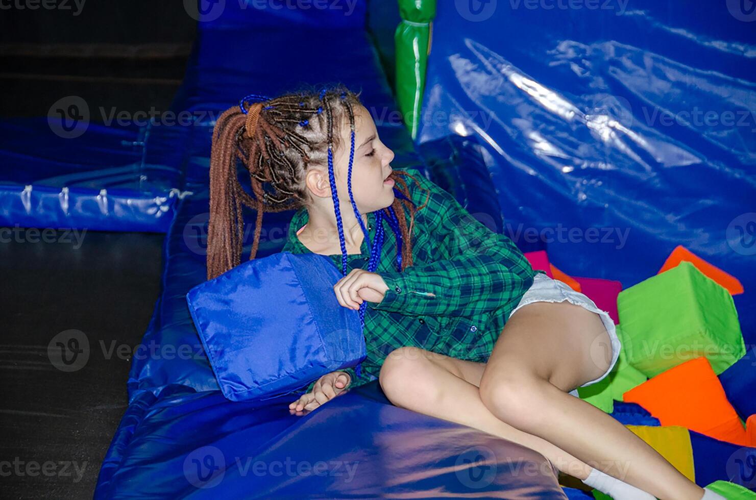 Little girl on the playground with colored plastic balls photo