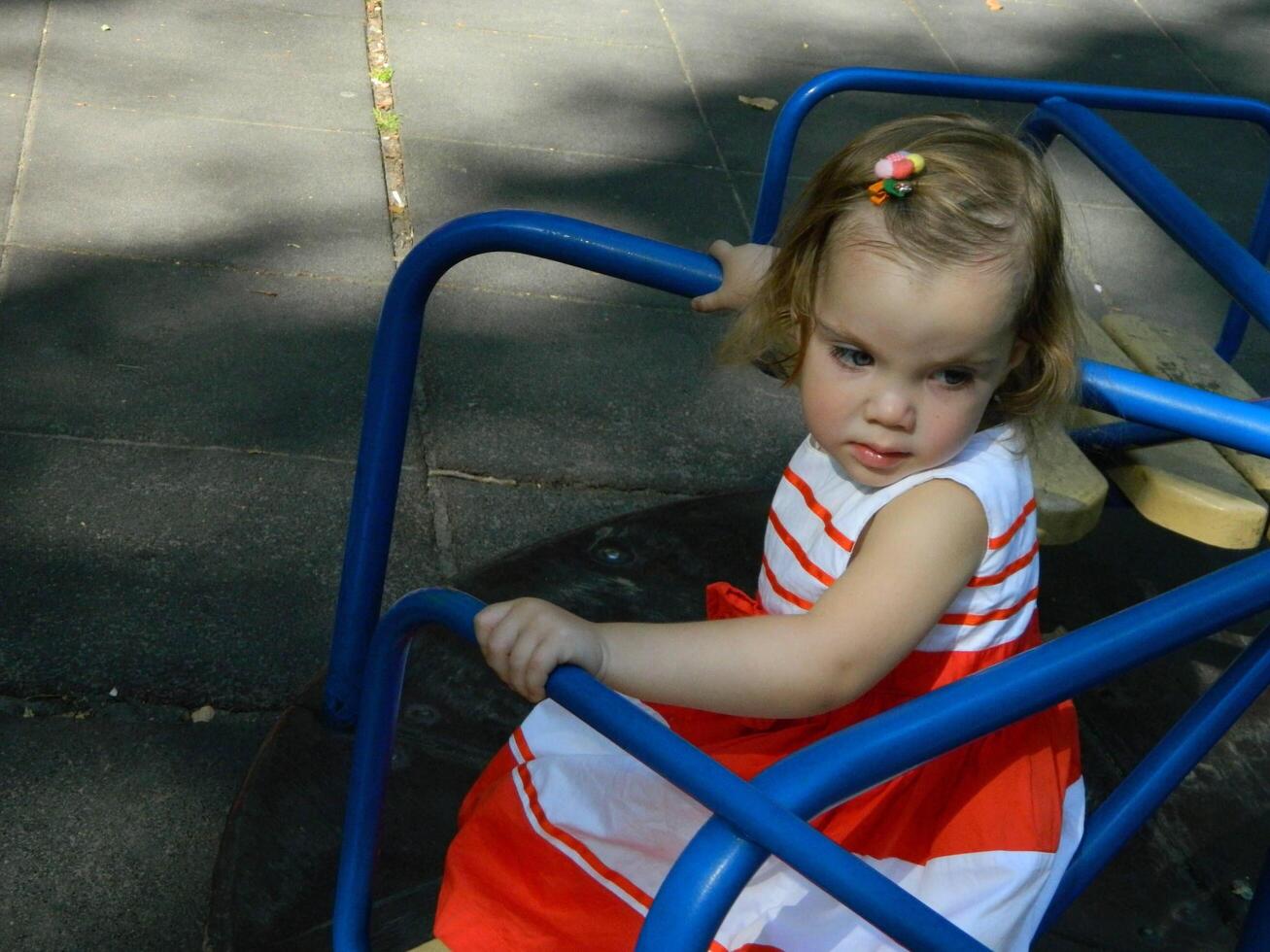 happy baby girl crawls and walks on the green lawn in the summer in the park photo