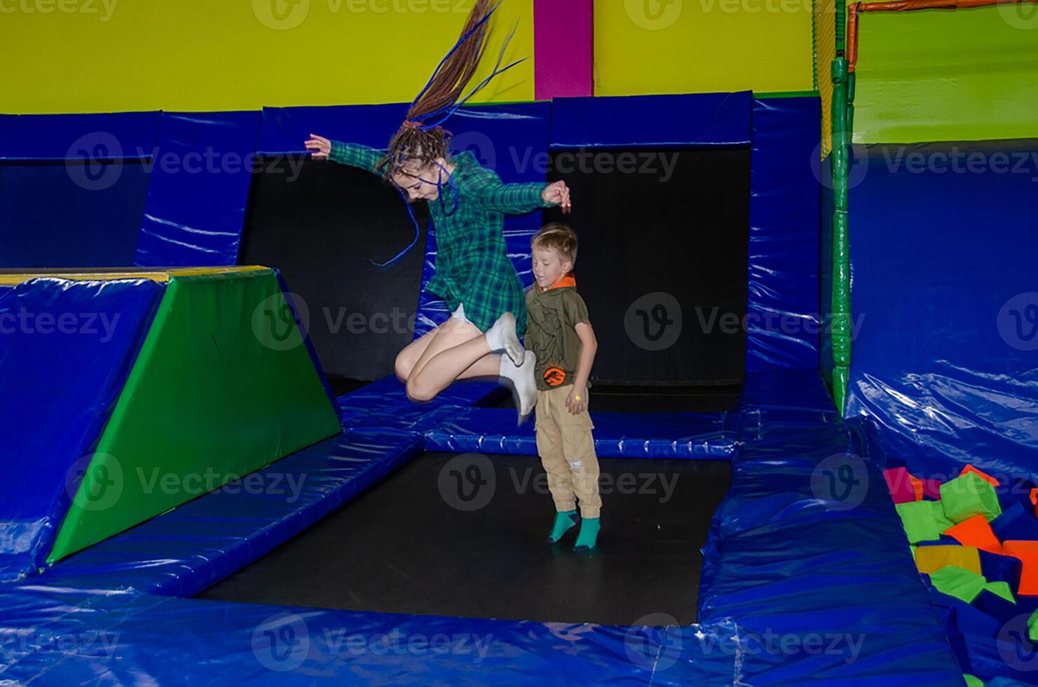 Happy active emotional preteen boy bouncing on trampoline photo