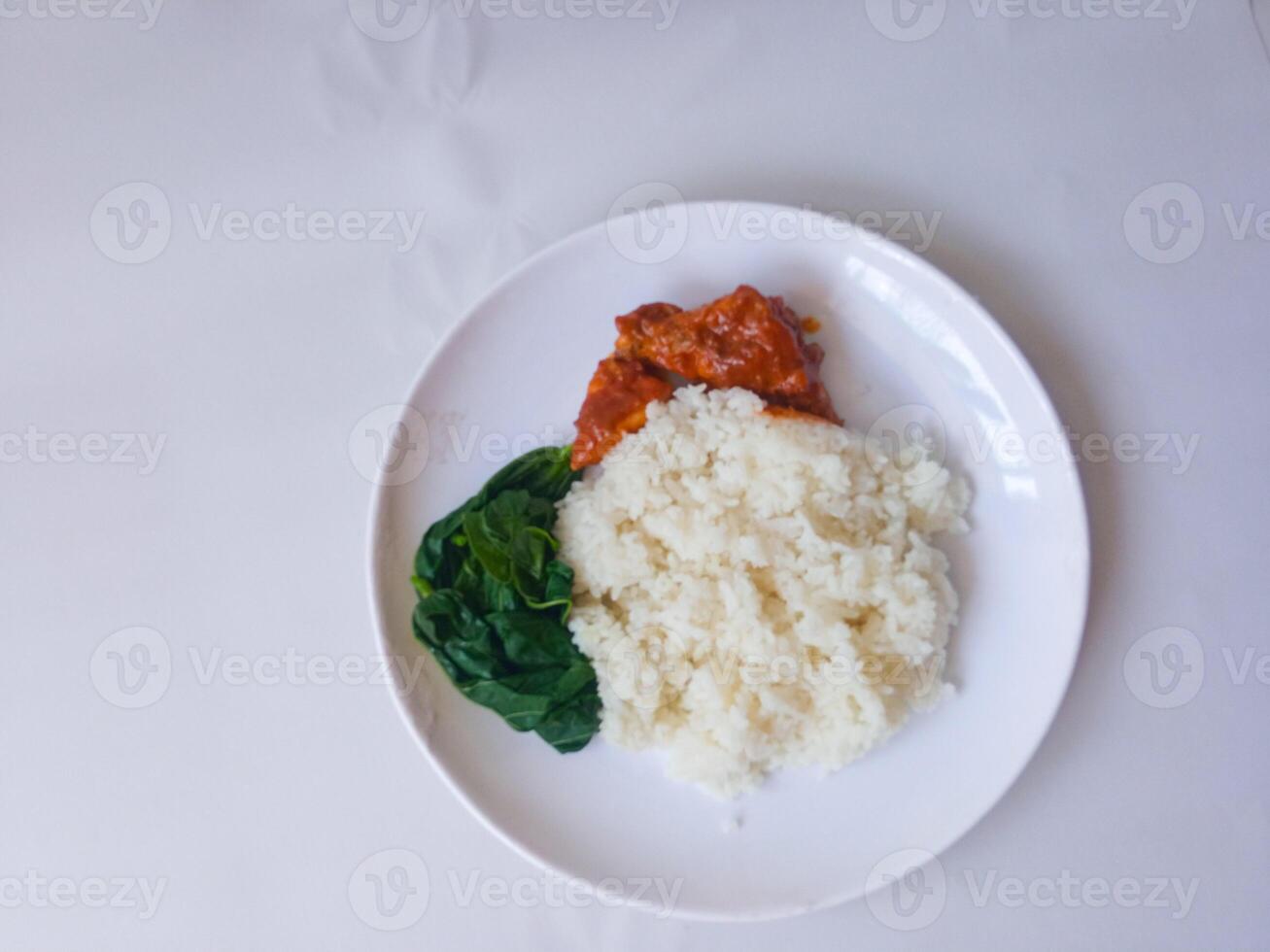 rice with padang rendang chicken side dish and cassava leaf vegetables on a white plate isolate on white photo