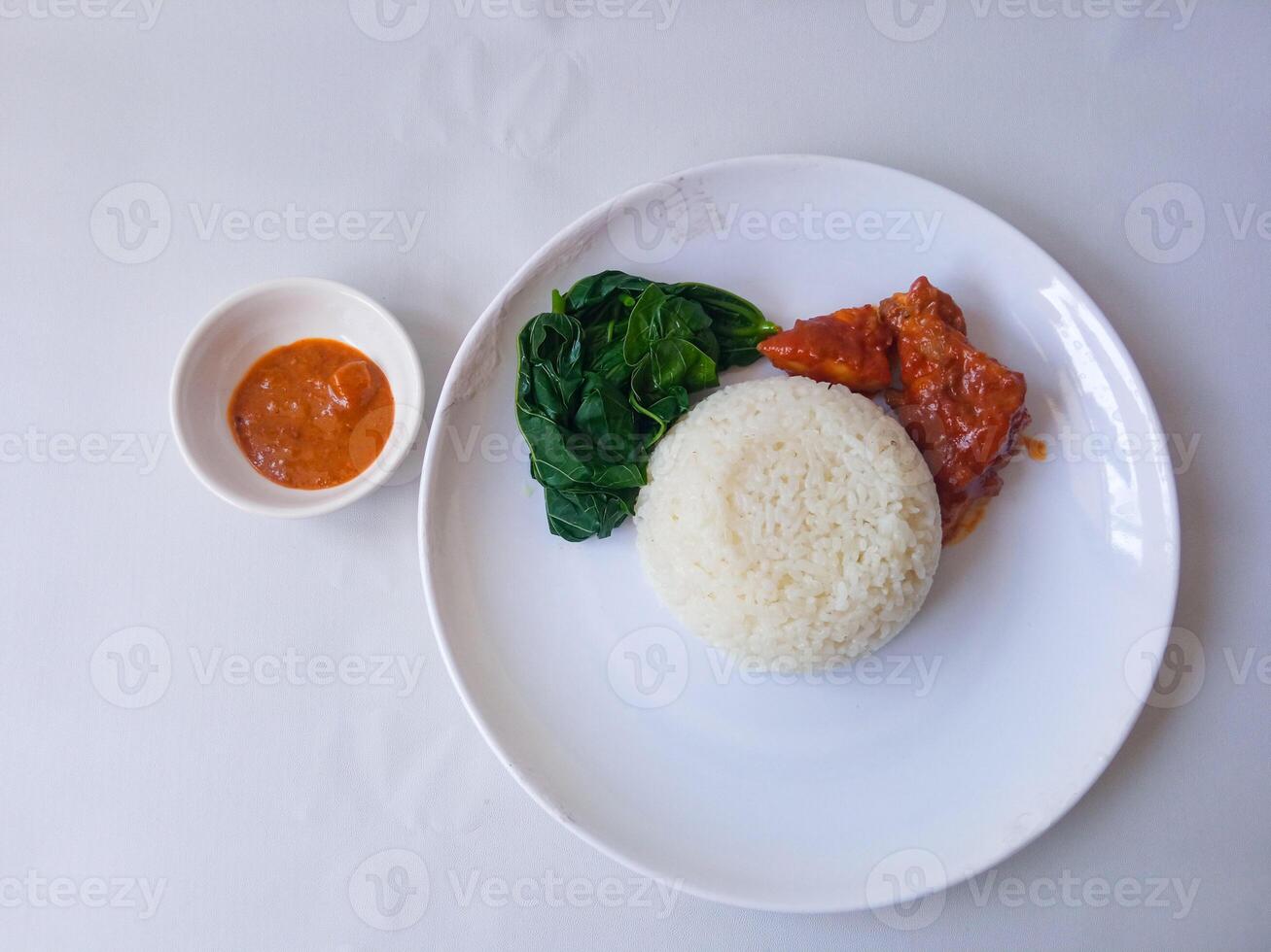 rice with padang rendang chicken side dish and cassava leaf vegetables on a white plate isolate on white photo