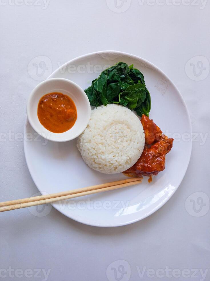 rice with padang rendang chicken side dish and cassava leaf vegetables on a white plate isolate on white photo