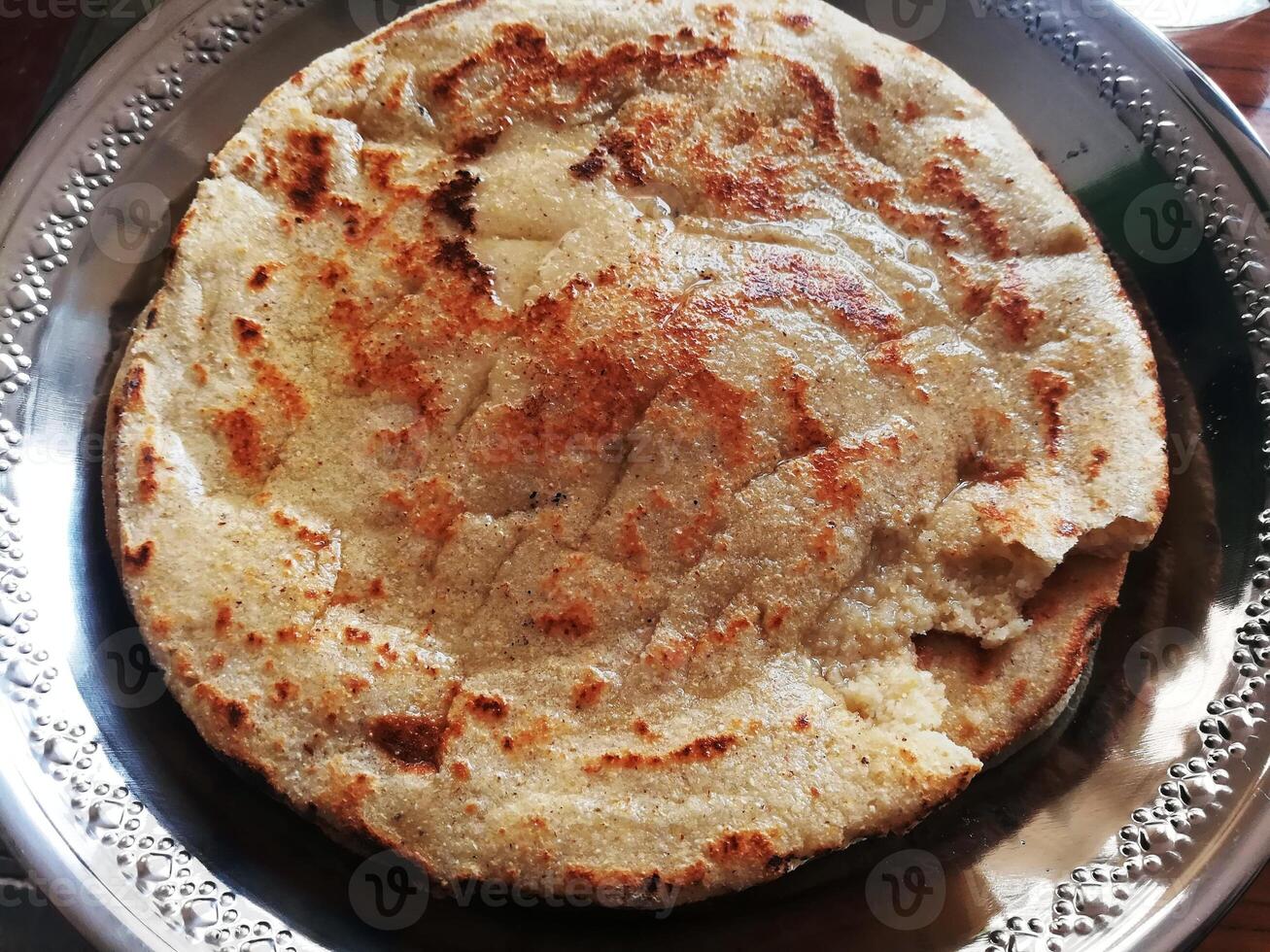 A delightful spread features savory mutton, tender chicken, flavorful daal, and a steaming cup of tea, complemented by an assortment of dry fruits for a touch of sweetness and texture. photo