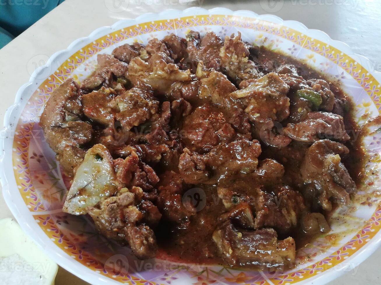 A delightful spread features savory mutton, tender chicken, flavorful daal, and a steaming cup of tea, complemented by an assortment of dry fruits for a touch of sweetness and texture. photo