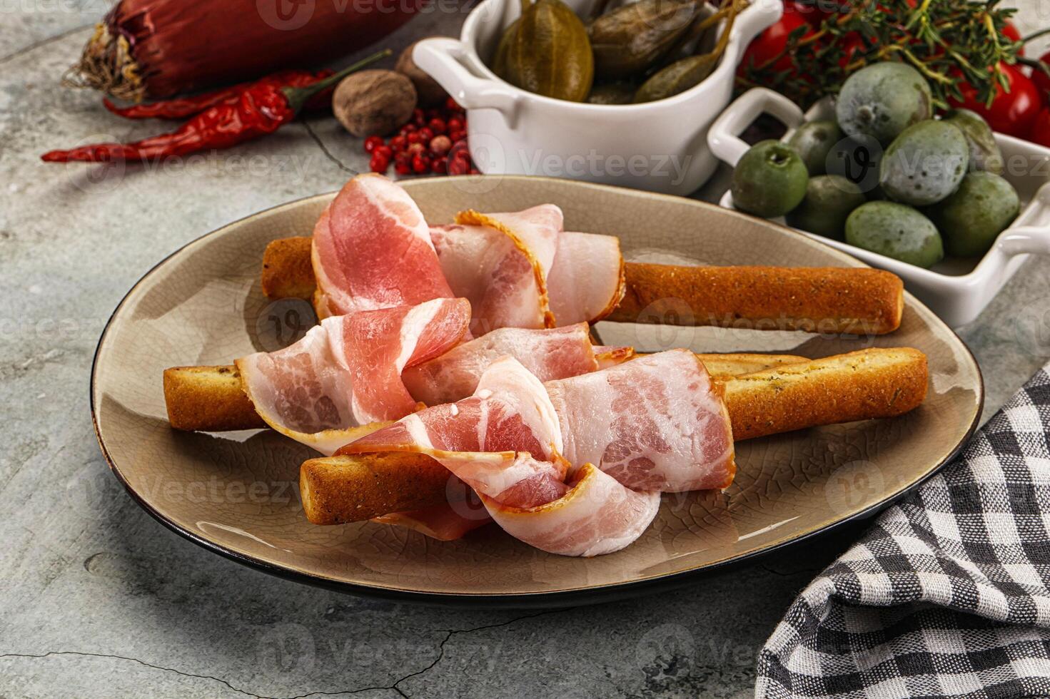 Antipasti - Grissini with pork bacon photo