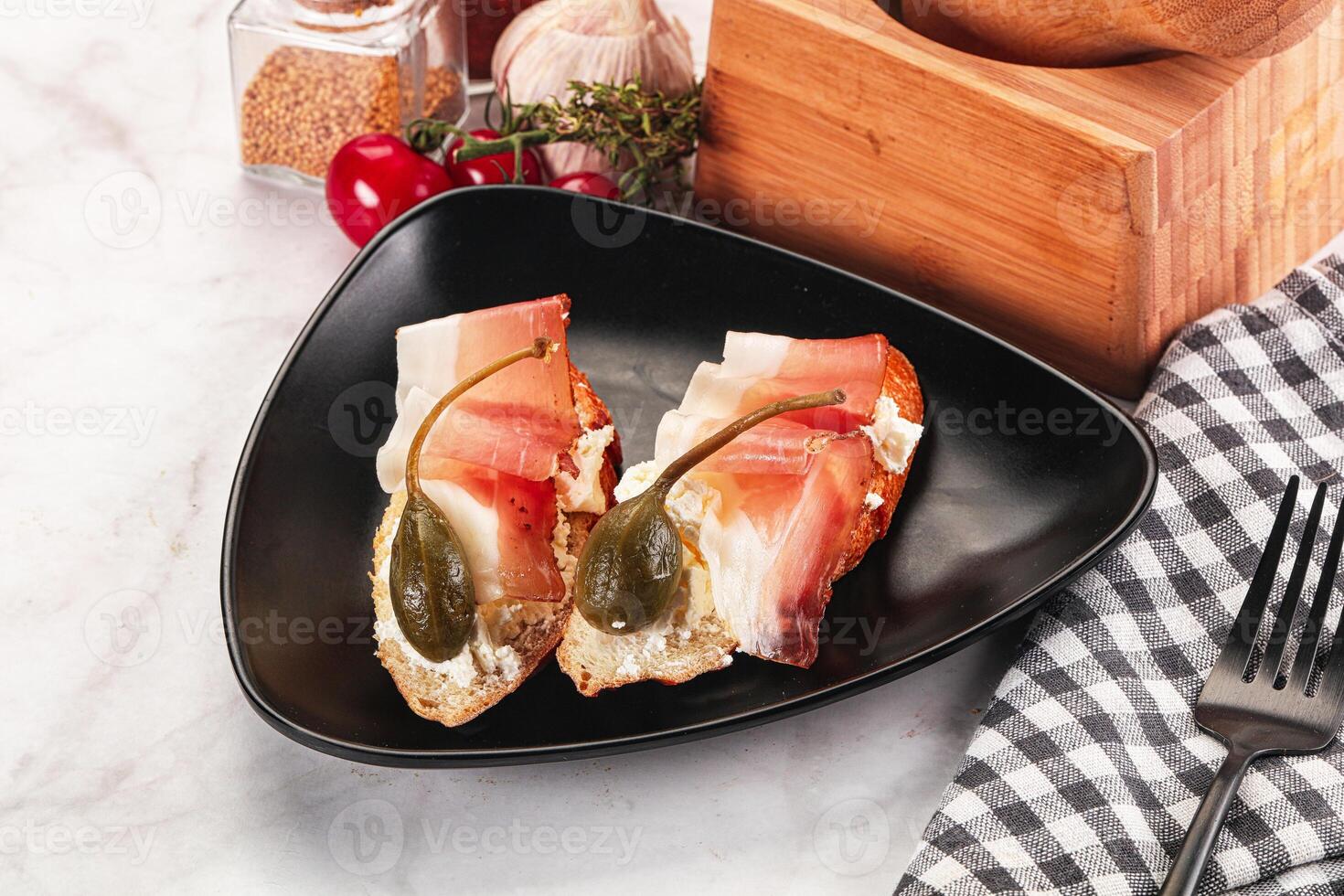 Bruschetta with jamon and caper berries photo